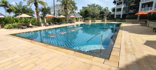 a swimming pool at a resort with chairs and umbrellas at Allamanda 3 Laguna in Bang Tao Beach