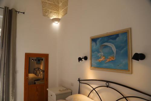 - une chambre avec un lit et une peinture murale dans l'établissement Salento casevacanza Maria, à Galatina