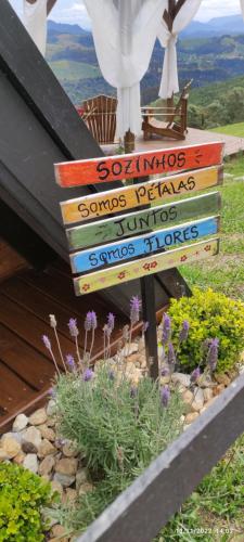 a stack of books next to a garden with flowers at Chalé Recanto da Coruja in Barracão
