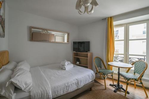 une chambre avec un lit, une table et des chaises dans l'établissement Paris, Opéra 4D...en plein coeur de la Paris, à Paris