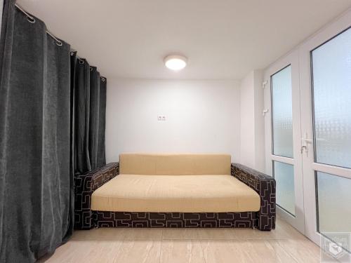 a bed in a room with curtains and a window at Renthouse Apartments City Gates #4 in Chişinău