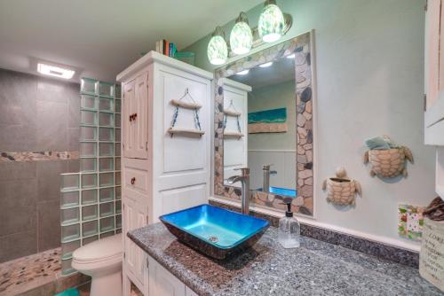 a bathroom with a sink and a toilet and a mirror at Coastal Kaunakakai Condo with Ocean-View Balcony! in Kaunakakai