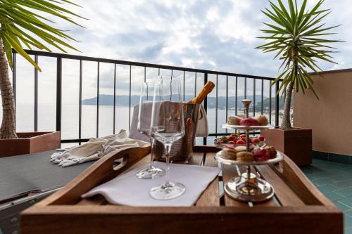 una mesa con copas de vino y comida en el balcón en Casa Isola, en Bergeggi