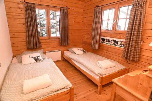 a bedroom with two beds in a log cabin at Verbier: Chalet avec vue magnifique in Verbier