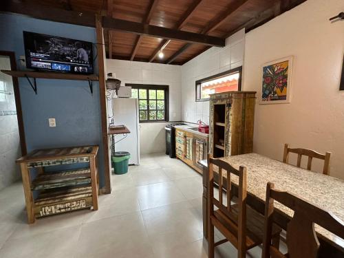 a kitchen with a counter and a table in a room at Chalés Solana localizados 50 metros do mar in Garopaba