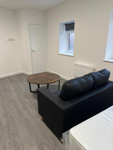 a living room with a couch and a table at London Rd Apartment's in Leicester