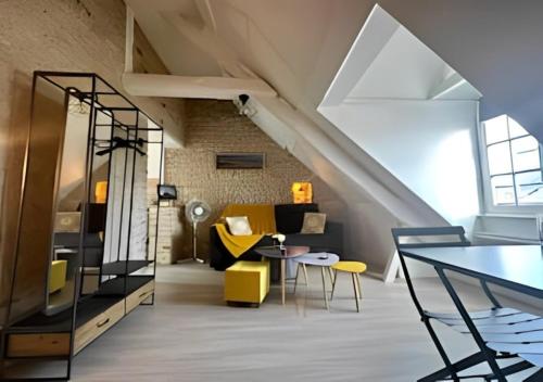 - un salon mansardé avec des meubles jaunes et noirs dans l'établissement Studio au centre historique de Bayeux, à Bayeux