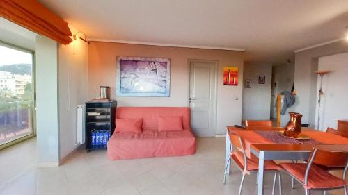 un salon avec un canapé rouge et une table dans l'établissement Le République 2, à Cannes