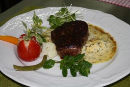 un plato de comida con carne y verduras en una mesa en Hotel Poggenstool, en Neuharlingersiel