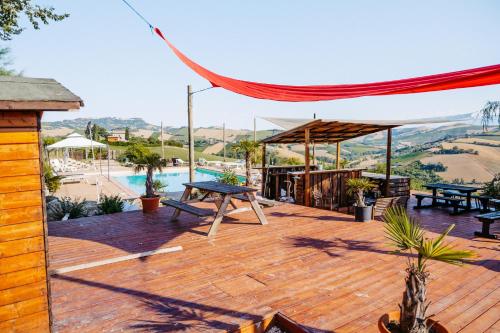 a wooden deck with a picnic table and a pool at Agricola La Casetta in Montefiore dellʼAso