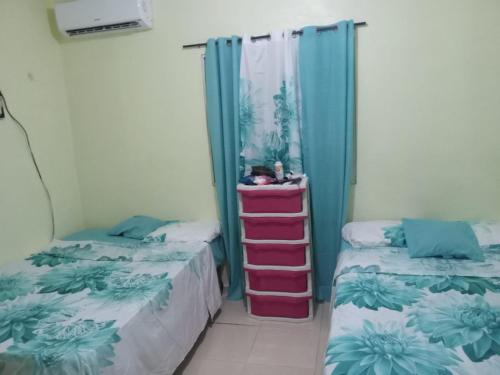 2 Betten nebeneinander in einem Zimmer in der Unterkunft Casa para la familia in Boca Chica