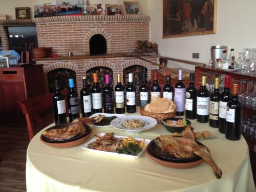 Pesquera de DueroにあるLa Posada de Pesqueraのワインと食べ物のボトルを一杯とテーブル