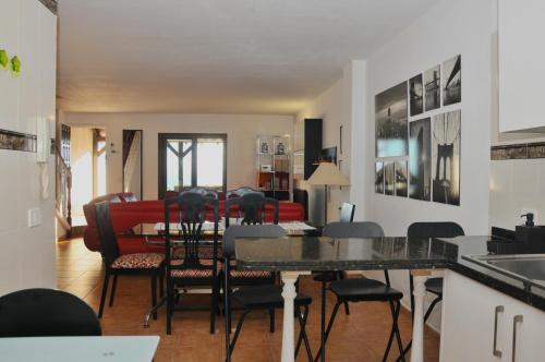 uma cozinha e sala de estar com mesa e cadeiras em Home2Book Maruja's House Ocean View & Wifi em Tabaiba