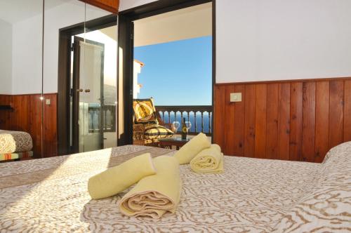een slaapkamer met een bed met handdoeken erop bij Home2Book Maruja's House Ocean View & Wifi in Tabaiba