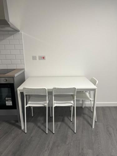 a white table and two chairs in a kitchen at London Rd Apartment's in Leicester