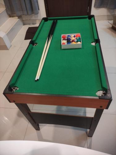 a pool table with two cuesticks on top of it at Regentown Home near ICE BSD in Cilandak