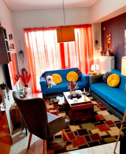 a living room with a blue couch and a table at Ζεστό παραδοσιακό σπιτι in Kalamata