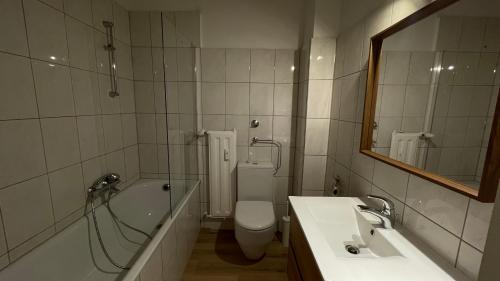a bathroom with a tub and a toilet and a sink at Cozy Apartment Blume in Hagen