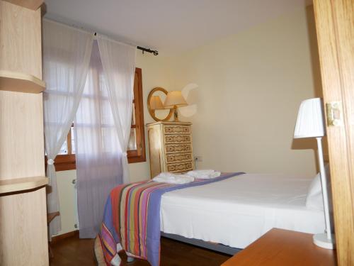 1 dormitorio con cama blanca y ventana en Francoli-Vacances Pirinenca, en Canillo