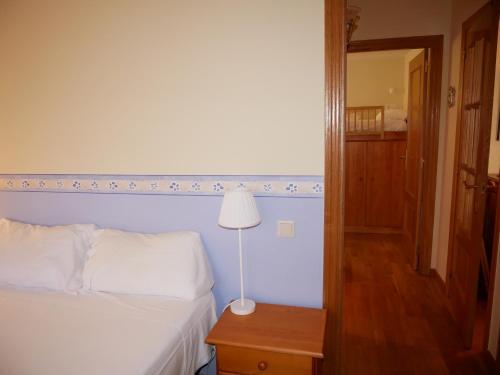 a bedroom with a bed and a lamp on a table at Francoli-Vacances Pirinenca in Canillo