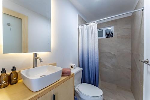 a bathroom with a sink and a toilet and a shower at Bed Away Studios in Cancún