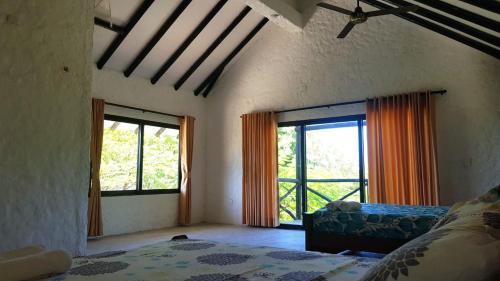 1 dormitorio con 2 ventanas y 1 cama. en Cabaña Recinto del Pensar, en Santa Marta