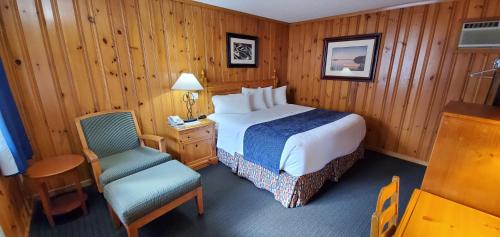 a hotel room with a bed and a chair at The Lake Motel in Lake George