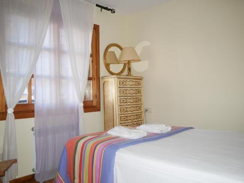a bedroom with a bed with a dresser and a mirror at Francoli-Vacances Pirinenca in Canillo