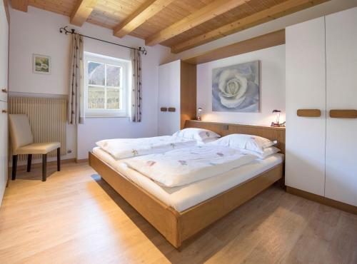 una camera con un grande letto e una finestra di Obermaratscher Apartments Residence a Lagundo