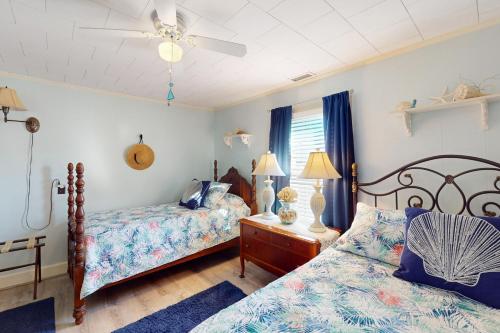 シャロッテにあるCoastal Cottageのベッドルーム1室(ベッド2台、シーリングファン付)