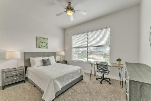1 dormitorio con cama, escritorio y ventana en Modern 2 Bedroom Apt , Pool, Gym, Parking Cs, en Dallas