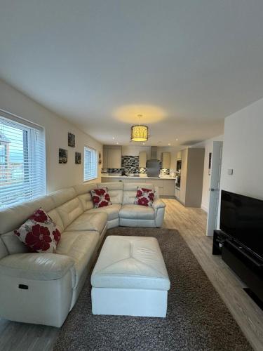 a living room with a white couch and a television at Home Away in Swanscombe