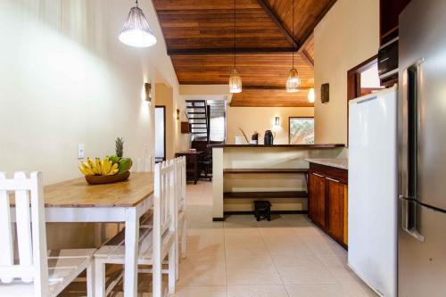 a kitchen with a table and a refrigerator at Casa Bia in Jericoacoara
