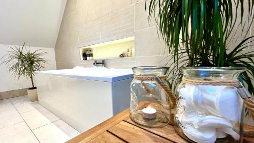 two glass vases sitting on a table in a bathroom at Bluebell Cottage with Hot Tub in Ballachulish