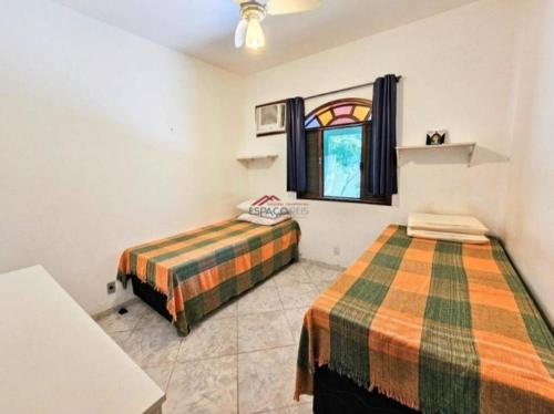- une chambre avec 2 lits et une fenêtre dans l'établissement Casa de praia, à Caucaia