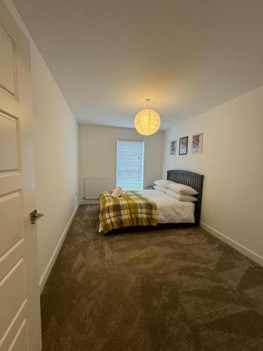 a bedroom with a bed with a blanket on it at Home Away in Swanscombe