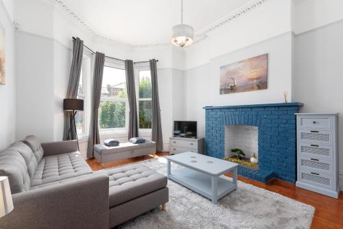 a living room with a couch and a fireplace at Bifolds, enclosed garden. Southport character home in Southport
