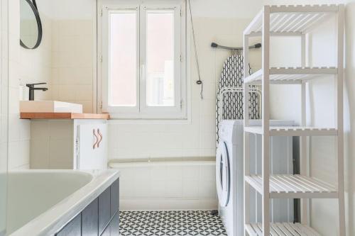 une salle de bain avec un lavabo et une machine à laver dans l'établissement Charmant 2 Pièces Climatisé Marseille Centre, à Marseille