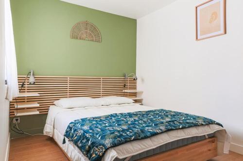 une chambre avec un grand lit avec une tête de lit en bois dans l'établissement Charmant 2 Pièces Climatisé Marseille Centre, à Marseille