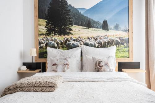 a bedroom with a large picture of a herd of animals at Pokoje Widokowe Sywarne in Kościelisko
