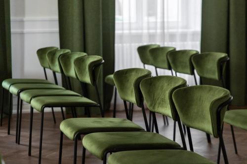 a row of chairs with green seats in a room at Konventa Sēta Hotel Keystone Collection in Rīga
