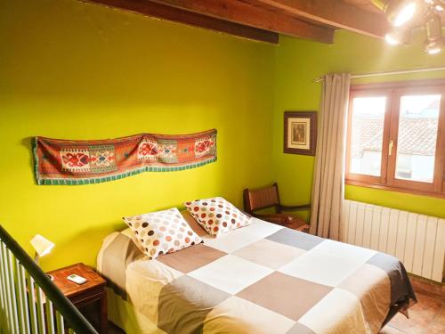 um quarto com paredes verdes e uma cama com almofadas em Casa rural de la Abuela em Cadreita