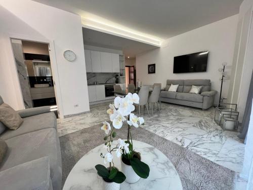 ローマにあるCasa Malupa Luxury Apartmentsのリビングルーム(白い花のテーブル付)