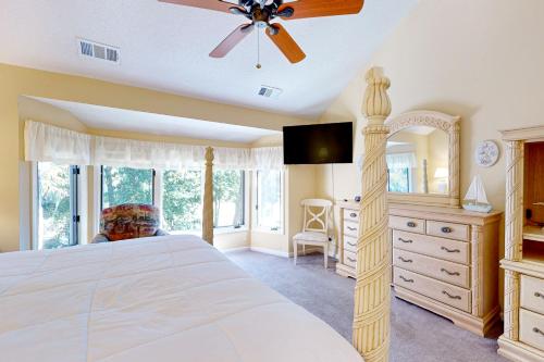 um quarto com uma cama e uma ventoinha de tecto em Eagle Watch em Hilton Head Island