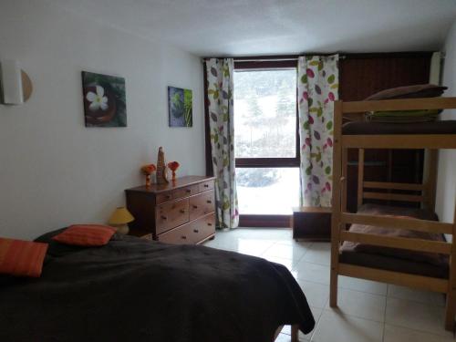 une chambre avec un lit, une commode et une fenêtre dans l'établissement 2 pièces 43m2 au Balcon de Villard Les Arolles, à Villard-de-Lans