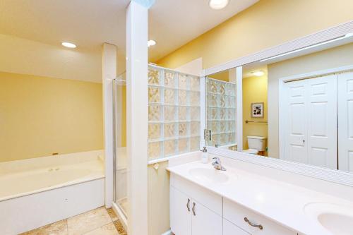 uma casa de banho com uma banheira e um lavatório e uma banheira em Eagle Watch em Hilton Head Island