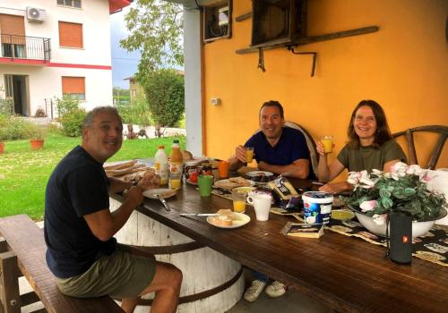 a group of people sitting around a wooden table at Casa Ortensia in Grions