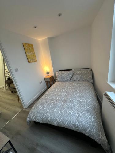 a bedroom with a bed with a gray comforter at Central Colwyn Bay F1 in Colwyn Bay