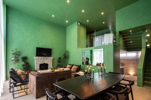 a living room with a table and a green wall at Colorful & Lively Centro Gem 5BR, Rooftop Patio in San Miguel de Allende