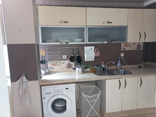a small kitchen with a washing machine and a sink at Superbe Appartement à proximité de la corniche in Casablanca